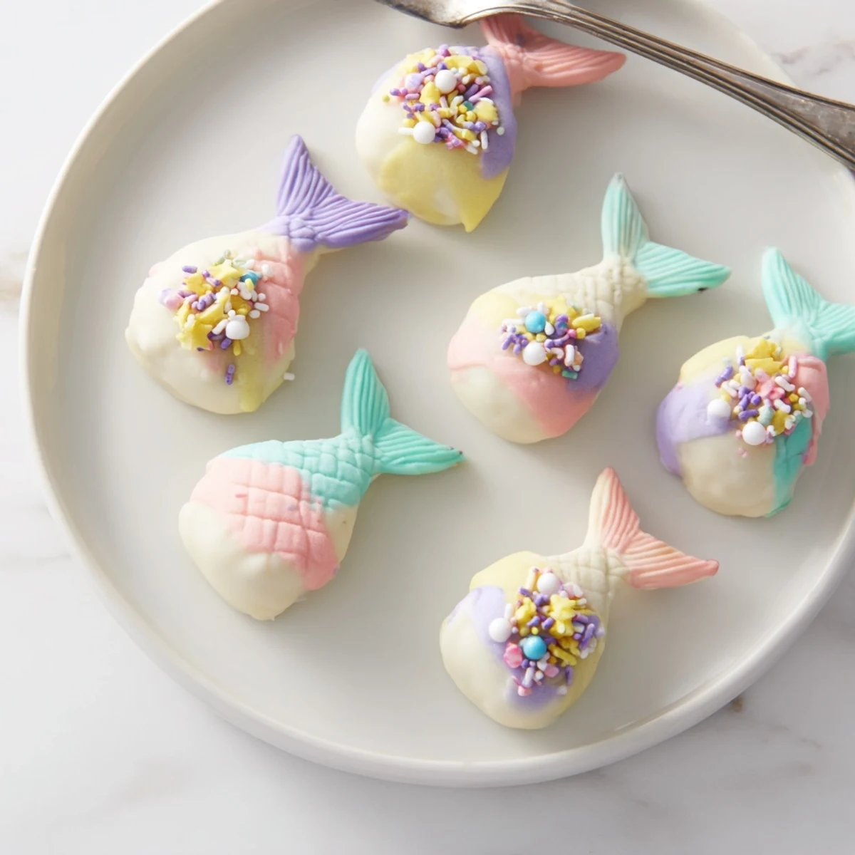 Close-up of vibrant, mermaid-themed Mignardises Queue de Sirène, perfect for an elegant tea party or celebration.