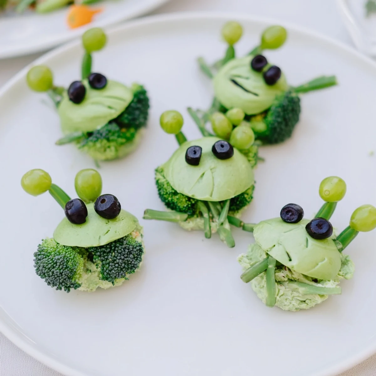Colorful Attaque dExtraterrestres snacks featuring sugar snap peas, broccoli, grapes, and creamy dip alien faces.