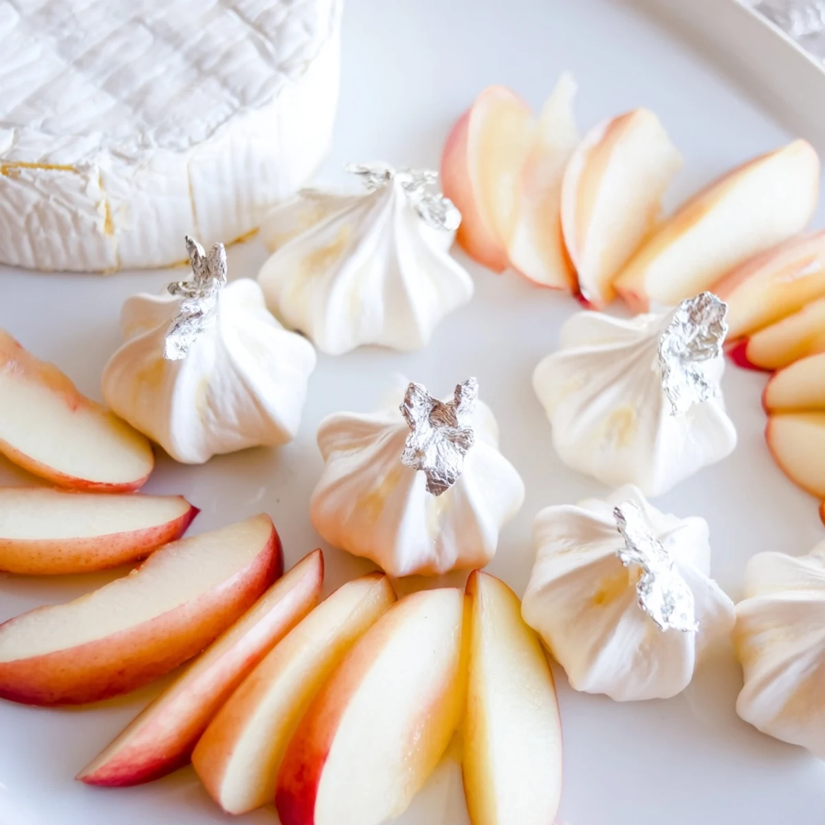 An all-white "Pearly Gates" cheese board presents creamy brie with sweet white peaches and meringue.