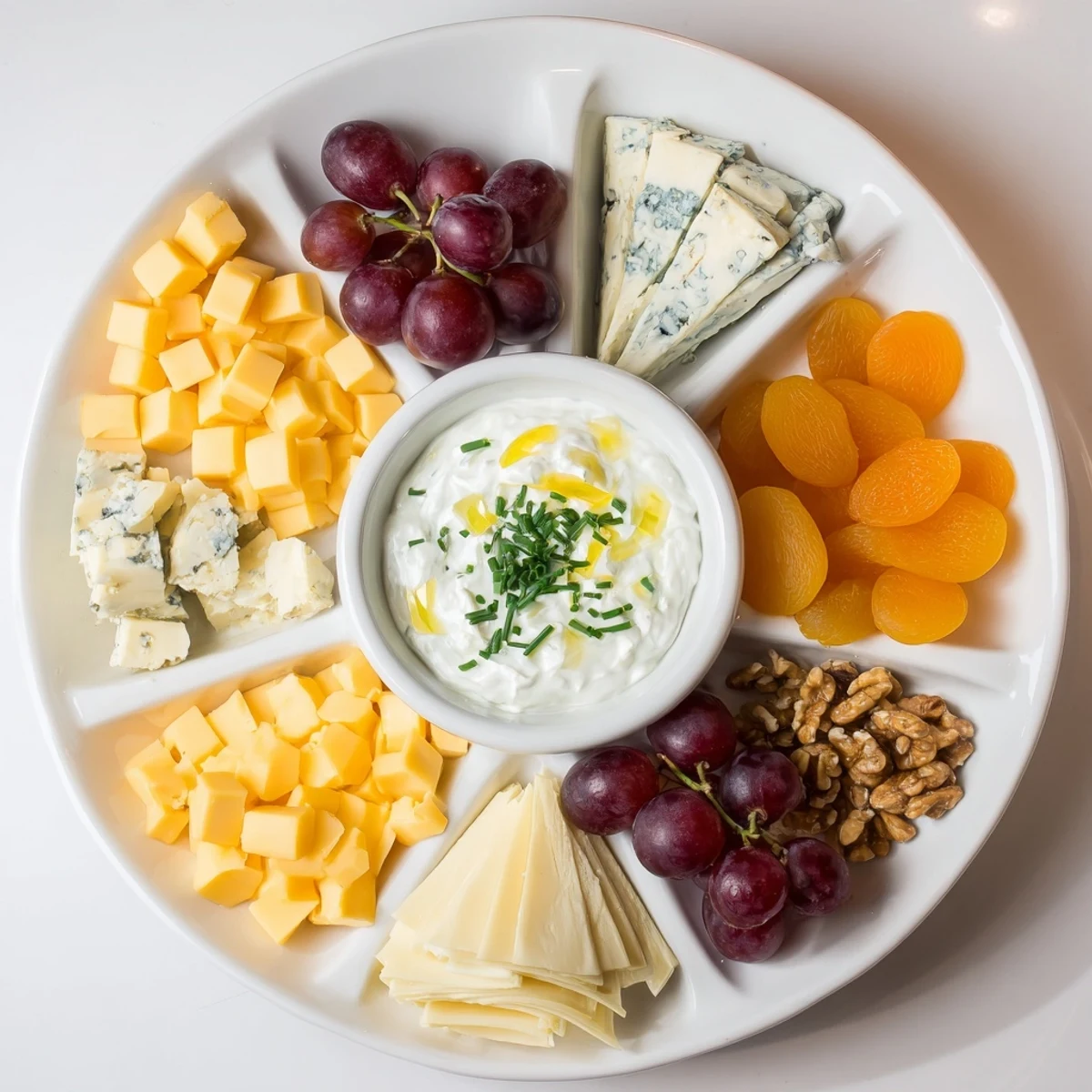 A beautifully arranged Celtic Cross Cheese Platter featuring various cheeses, grapes, and nuts.
