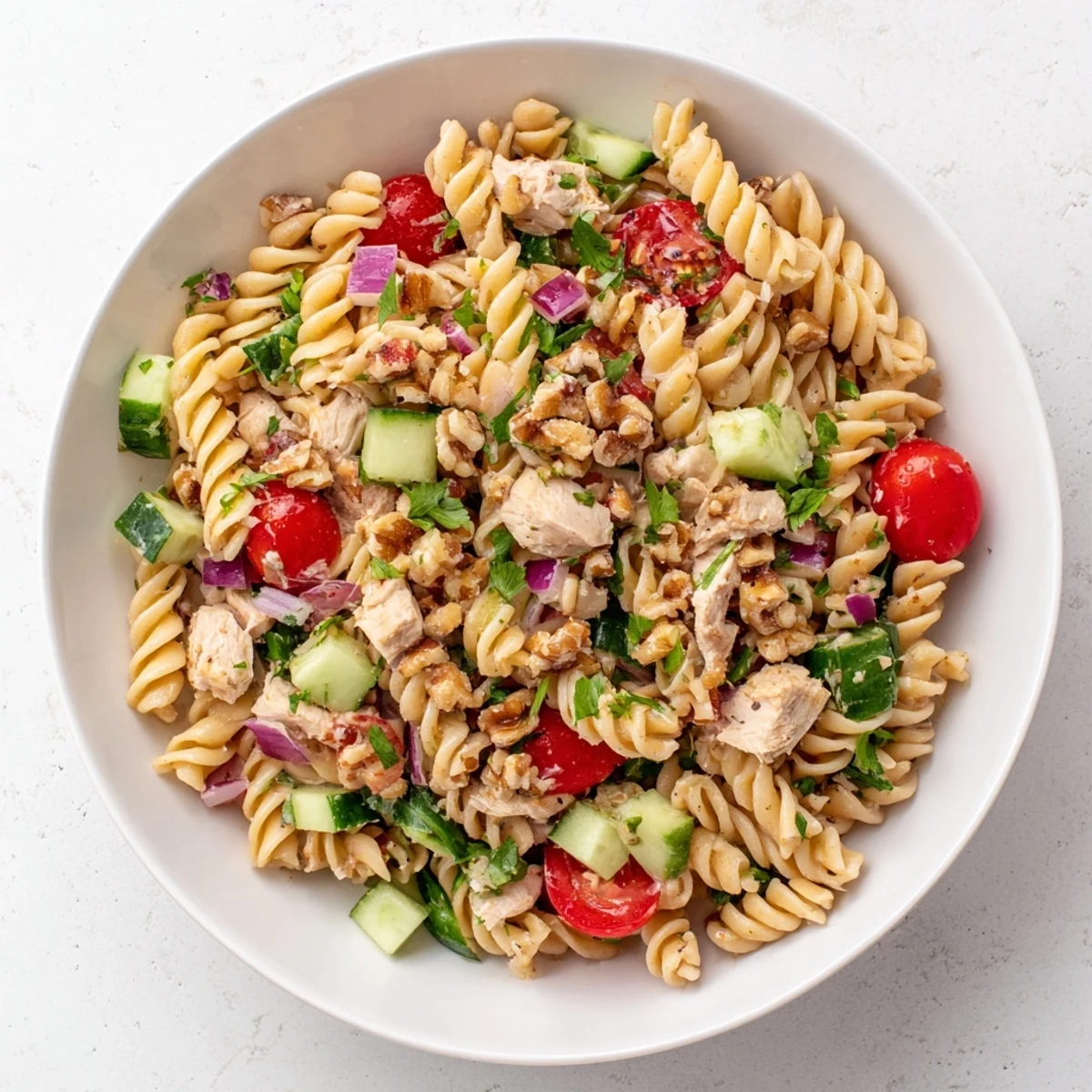 A close-up view of the Pasta Salad with Cranberry Vinaigrette displays tender chicken and a tangy, flavorful vinaigrette.