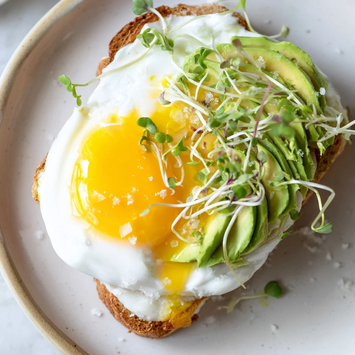 Fluffy cloud toast 2.0 with golden egg whites, avocado roses, and drizzled honey, ready to eat.