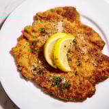 Perfectly cooked, crispy Air Fryer Wiener Schnitzel, ready to eat alongside fresh parsley garnish.