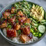 Genussvoll angerichteter Salmon Rice Bowl mit knusprigen Gurken, würziger Sriracha-Mayo und goldbraunen Sesamsamen auf fluffyem Reis.