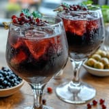 Frisch zubereiteter Black Currant and Cassis Cocktail mit Eiswürfeln und Zitronenschale