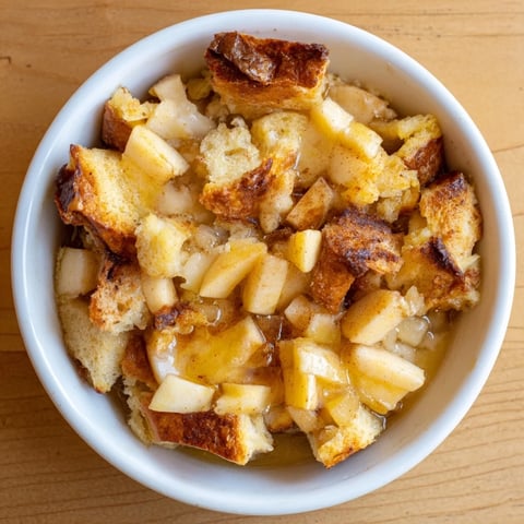 Golden-brown bread pudding with apples and cinnamon, a warm dessert ready to be served.