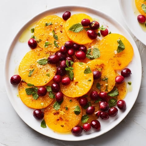 Slices of winter fruit salad: juicy oranges and bright red cranberries, ready to serve.