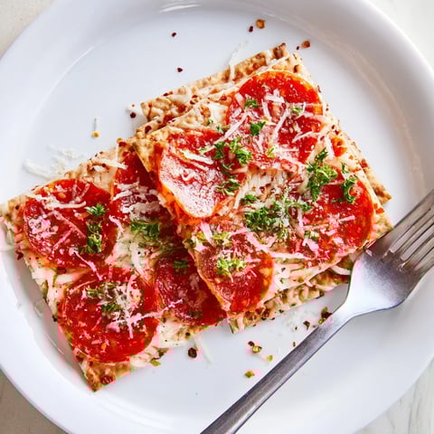Warm, melty Savory Bites: Pepperoni stacked on crackers, a perfect, flavorful appetizer ready to enjoy.