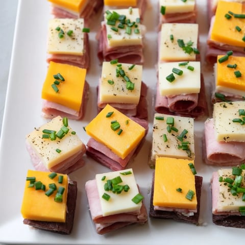 Checkerboard Picnic Bites ready to eat, featuring a savory arrangement of deli meats and assorted cheeses.