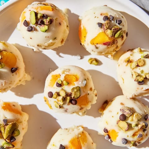 Frozen Peach Yogurt Bites arranged on a tray, a refreshing summer treat with peach chunks.
