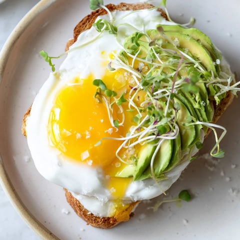 Fluffy cloud toast 2.0 with golden egg whites, avocado roses, and drizzled honey, ready to eat.