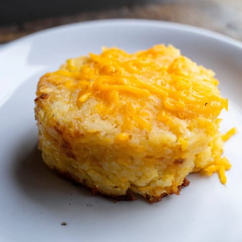 A stack of freshly fried Secret 4-Ingredient Mashed Potato Cakes with melted cheese and a fluffy interior.