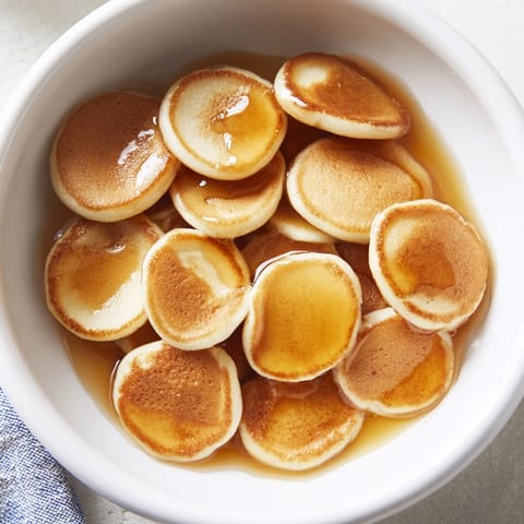 Mini pancake cereal, stacked in a bowl and drizzled with golden syrup, perfect breakfast.