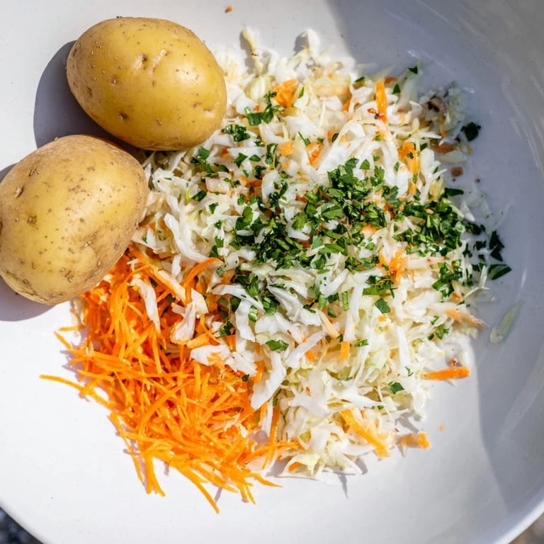 Close-up of fresh Krautsalat and golden boiled Pellkartoffeln, a classic German pairing for dinner.