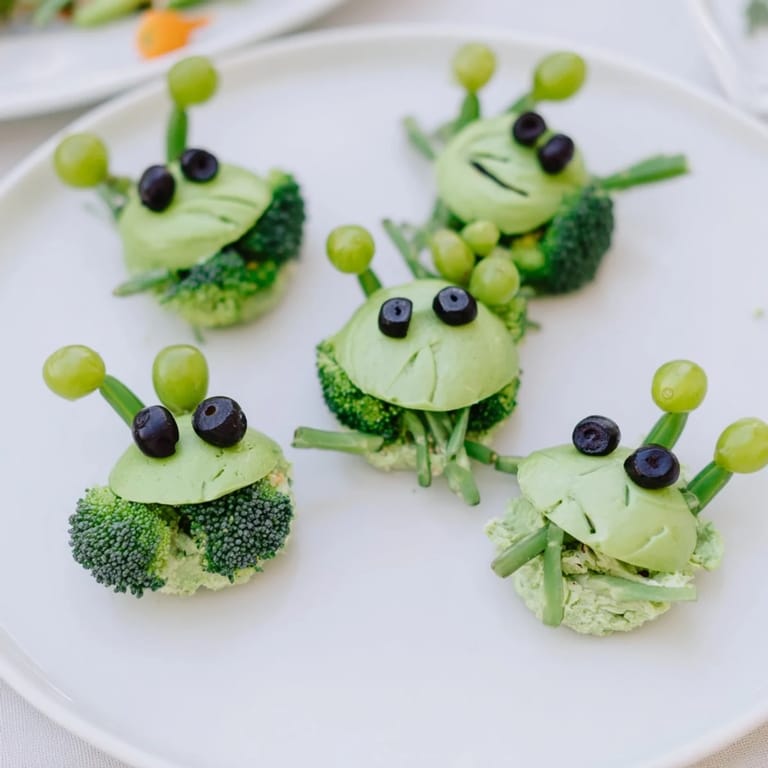 Colorful Attaque dExtraterrestres snacks featuring sugar snap peas, broccoli, grapes, and creamy dip alien faces.